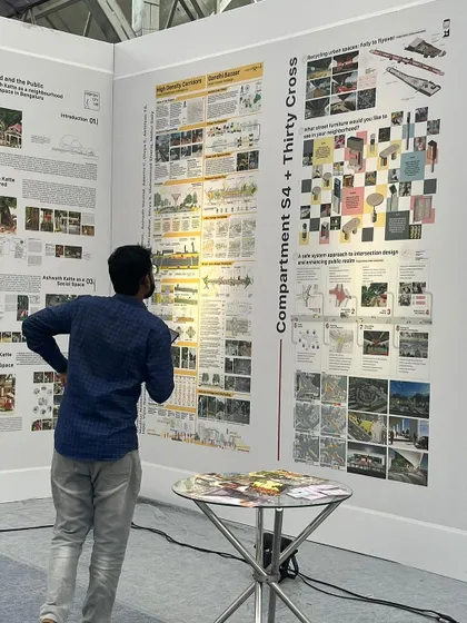 A team member explaining our detailed research and design panels at the Namma Raste exhibition, engaging with visitors and other urban practitioners.