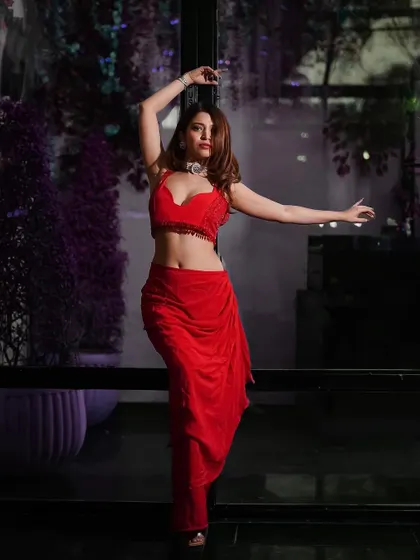 An expressive pose by the window, using the ambient light to create a dramatic and alluring mood for this modern red ensemble.