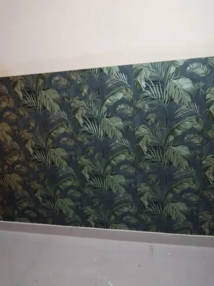 A dark and moody tropical leaf wallpaper, creating a sophisticated and dramatic accent wall.