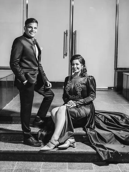 A stylish black and white portrait of the couple seated on steps, looking like movie stars.