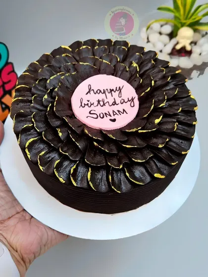 A close-up of our bestseller chocolate petal cake, this time with a pink "Happy Birthday" plaque.