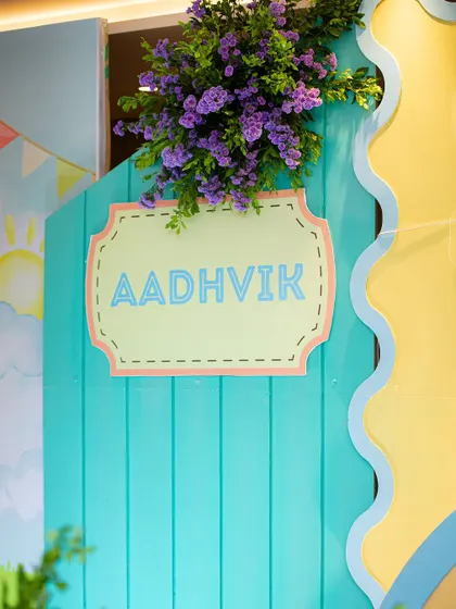 A close-up of the custom "Aadhvik" sign, designed with a charming, stitched border effect to match the soft and crafty feel of the party.