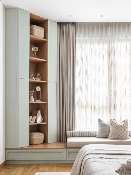 On the other side of the grandparents' room, we created this charming window seat. It doubles as a cozy reading nook with both open and closed storage, offering a serene spot to relax while basking in natural light. It's neat, clean, and just pretty.