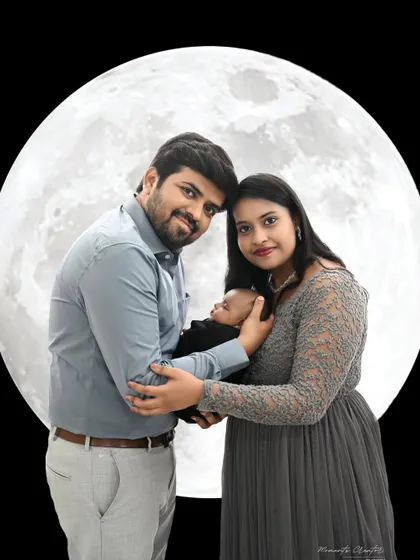 A sweet family portrait in front of a glowing moon. This creative shot is a wonderful way to capture the magic of welcoming a new baby into the family.
