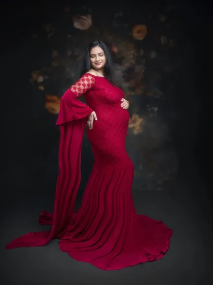 Every frame tells a story, and this one speaks of elegance, grace, and timeless beauty. This stunning mommy-to-be in a red gown is a masterpiece of art and emotion.
