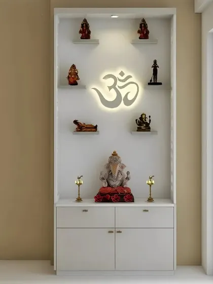 A clean, all-white pooja unit designed for a bright and modern home. The focal point is a softly illuminated OM symbol, with multiple shelves for idols and a spacious four-drawer cabinet below, demonstrating how minimalist design can create a powerful spiritual corner.