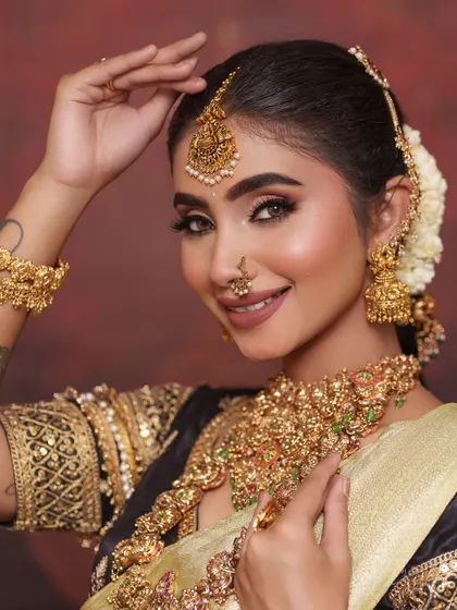 Adjusting her hair, this shot gives a lovely view of the jhumkas and the side profile of the bridal look.
