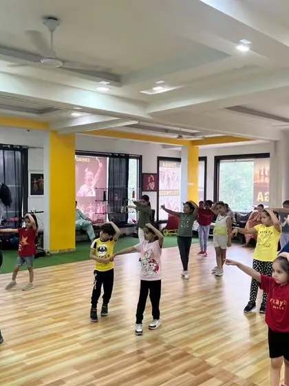 An instructor leading a kids' jazz and Bollywood class, ensuring every child is engaged and learning the steps correctly.
