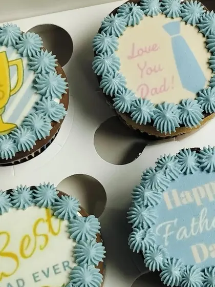A close-up on four of the Father's Day cupcakes, allowing a better look at the details on the edible toppers, like the trophy and tie designs.