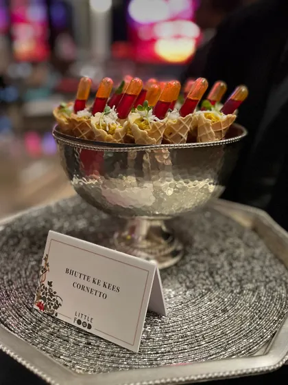 Our creative "Bhutte Ke Kees Cornetto," a savory corn mixture served in a mini waffle cone with a pipette of sauce. This playful and interactive appetizer is always a conversation starter at parties.