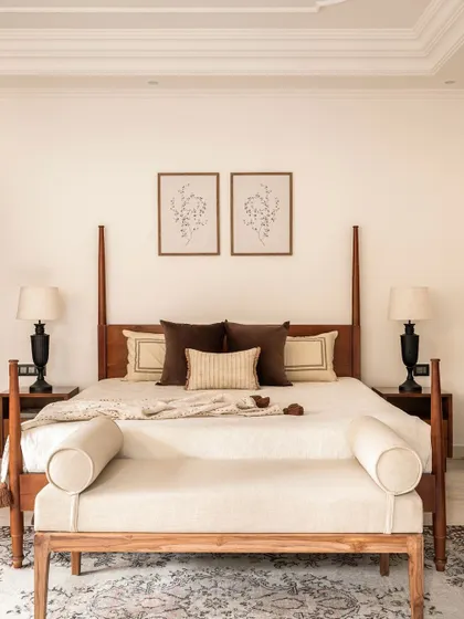 A direct view of the four-poster bed, showcasing its clean lines and the simple, elegant styling. The matching bedside tables and lamps create a sense of symmetry and order, contributing to the room's tranquil mood.