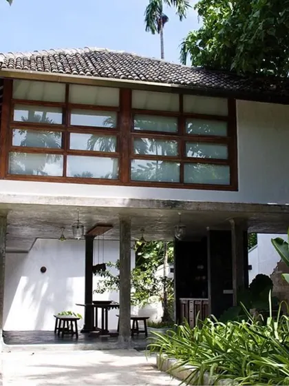 The main villa entrance by day, showing the elevated structure and the large window of the room above.