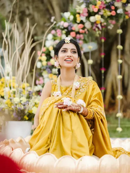 A radiant bride at her Haldi ceremony. I designed this custom lotus-shaped seating surrounded by soft, pastel flowers to make her feel like she was floating in a garden.