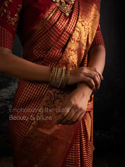 Emphasizing the outfit's beauty and allure. This close-up shows the rich texture of a red Kanchipuram saree, woven with pure gold zari by my artisans.