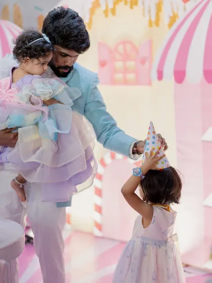A heartwarming moment between a father and his children at a Candyland-themed party.