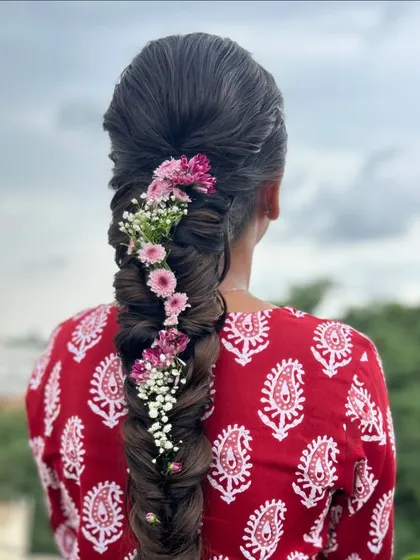 A detailed close up of the fishtail braid, highlighting the texture and the delicate flowers woven into it.