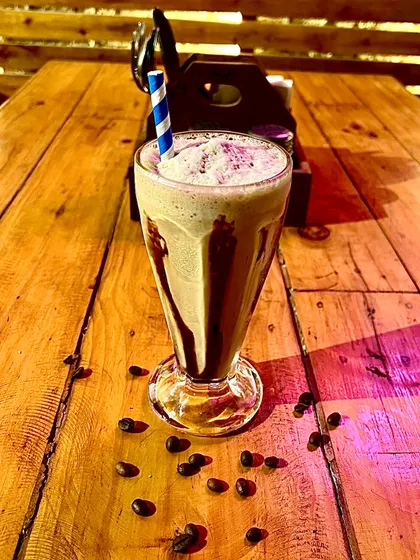A tall glass of our refreshing cold coffee, drizzled with chocolate sauce.