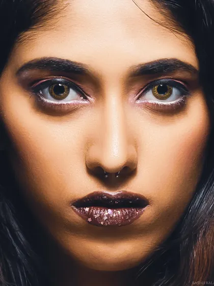 An intense close-up beauty shot with a focus on the eyes and glittery lips. This high-impact image is perfect for an editorial beauty story.
