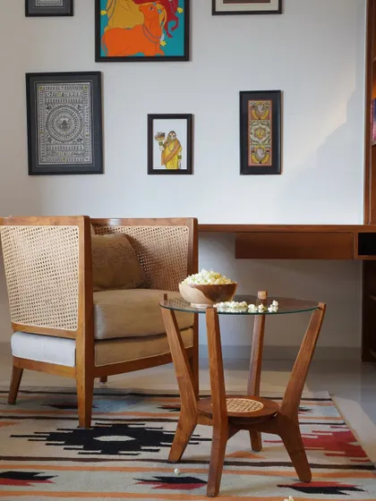 I love seeing my pieces in their new homes. Here, my high-back rattan armchair and teak coffee table create a cozy, art-filled corner for a client.
