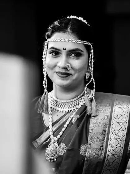 A beautiful black and white portrait of the bride, Poorva, during the wedding vidhis. Her expression is full of emotion and anticipation.