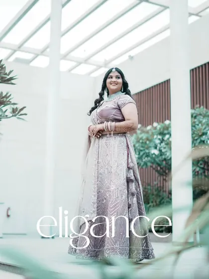 A beautiful solo portrait of the bride in her elegant lavender lehenga, with the word "elegance" overlaid.