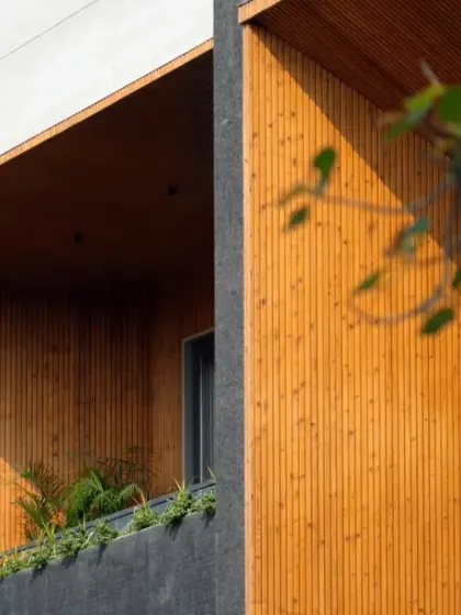 The façade of the House of Dancing Screens is an exquisite blend of contrasting materials. The warmth of the wooden louvers and terracotta screens is balanced by the cool, dark tones of the surrounding structure, adding depth and vibrancy.