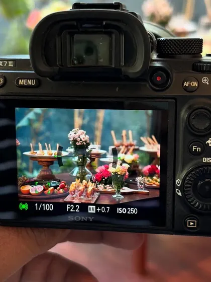 A "camera-in-camera" view of my work. This behind-the-scenes shot shows a photographer framing the perfect image of the vibrant grazing table at the Savana event.