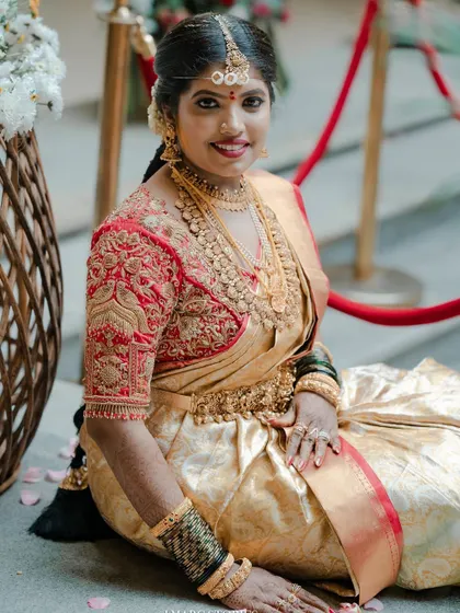 The bride looking radiant and happy, her custom red blouse a stunning centerpiece of her bridal look.