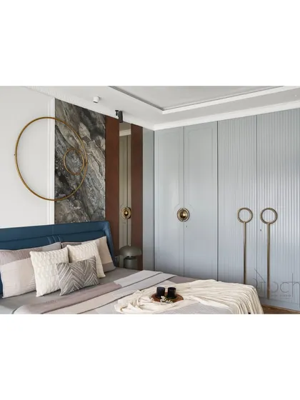 A view of the master bedroom's custom wardrobe, which features a soft pastel grey finish and unique circular brass handles. The fluted texture adds a subtle, classical detail to the modern design.