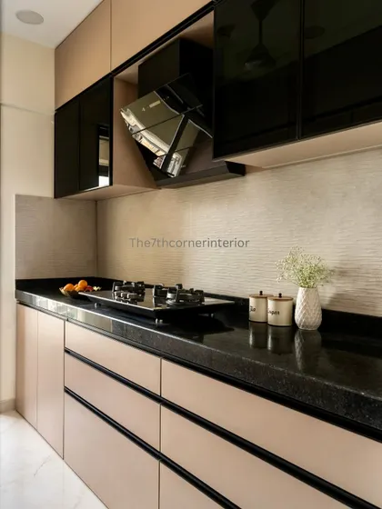 A stylish kitchen design featuring two-tone cabinetry with glossy black upper cabinets and matte beige lower cabinets. The black granite countertop and textured backsplash create a sophisticated and modern look.