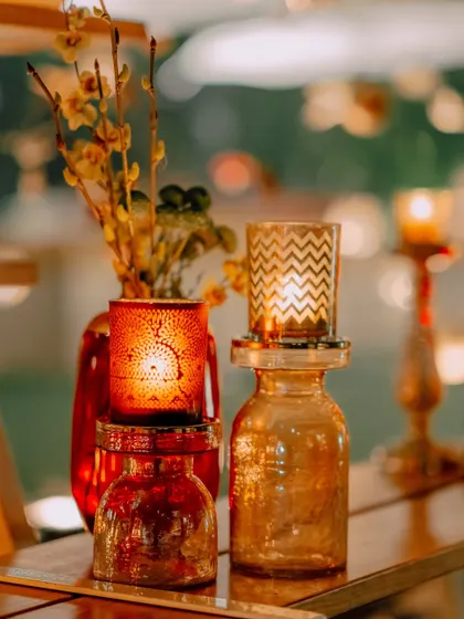 Balmy nights washed in gold. A close-up of our candle decor, with patterned votives casting a warm, inviting glow.