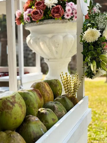 A beautifully decorated coconut cart, adorned with flowers, adds a rustic and tropical charm to any event.