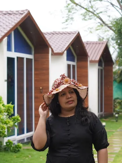 A guest enjoying the view of our A-frame cabins at the Nandi Hills resort. The unique architecture and green lawns create a picturesque setting.