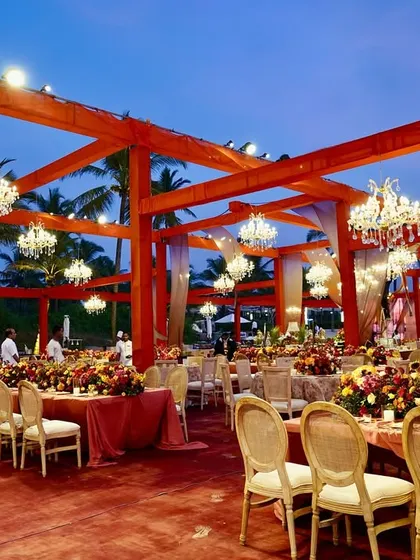 A wider view of the Goa reception, showing the grand scale of the open-air structure, the warm lighting, and the beautiful tablescapes.