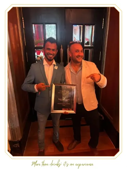 Two of our team members proudly holding an award plaque. Every recognition is a team effort.