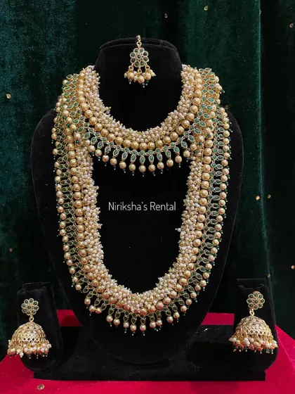 For a softer look, I offer this beautiful multi-layered pearl necklace set with green bead accents and matching jhumkas.
