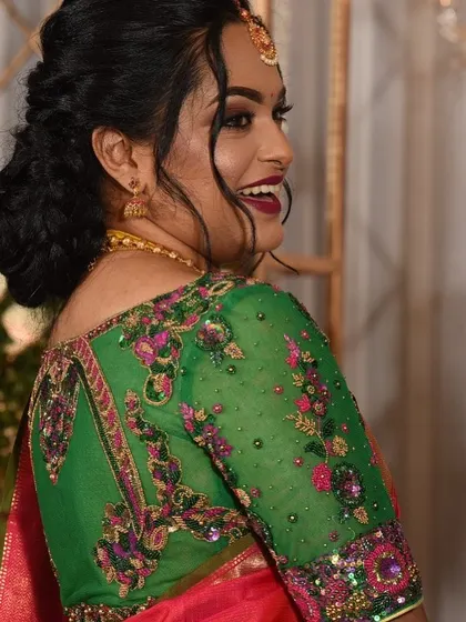 A beautiful shot of a client wearing a green blouse with multi-colored floral embroidery. The sheer sleeves make the detailed threadwork pop.