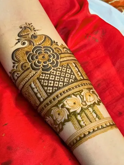 This arm band features a peacock on top of a central flower, surrounded by a dense net pattern. It's a beautiful and unique composition.
