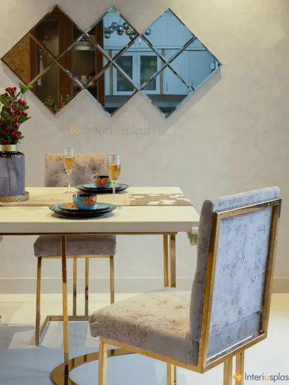 This dining room setup is both stylish and functional. The gold-legged chairs and table add a touch of luxury, while the mirrored wall art makes the space feel more expansive.