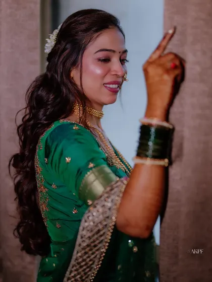 A candid shot of the bride enjoying her engagement party. The hairstyle is a modern take on a traditional look, with soft waves and a small hair accessory.