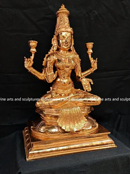 A brightly polished bronze sculpture of Goddess Lakshmi. The warm, golden hue of the metal gives the piece a celestial glow, emphasizing her role as the goddess of fortune.