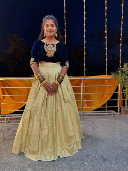 A client looking stunning in a dark velvet crop top with gold embroidery, paired with a flowing beige skirt for an evening event.