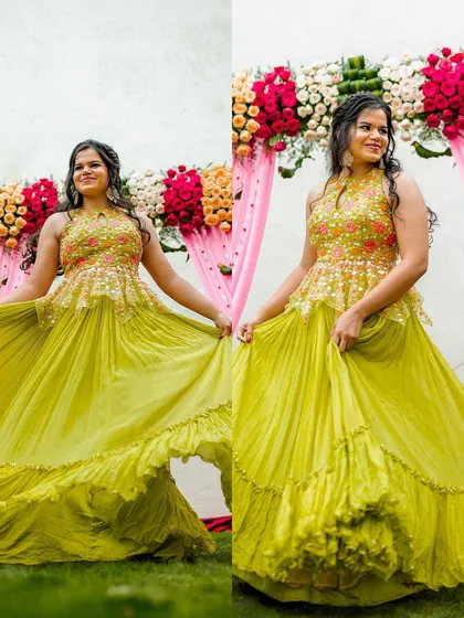 A happy bride twirling in her vibrant mehendi ceremony outfit. The henna on her hands adds to the festive and colorful atmosphere of the celebration.