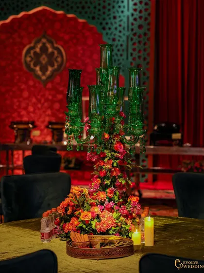 A clearer view of the green glass candelabra centerpiece, which provides a striking color contrast to the predominantly red theme. The design is a testament to crafting unique, memorable details.