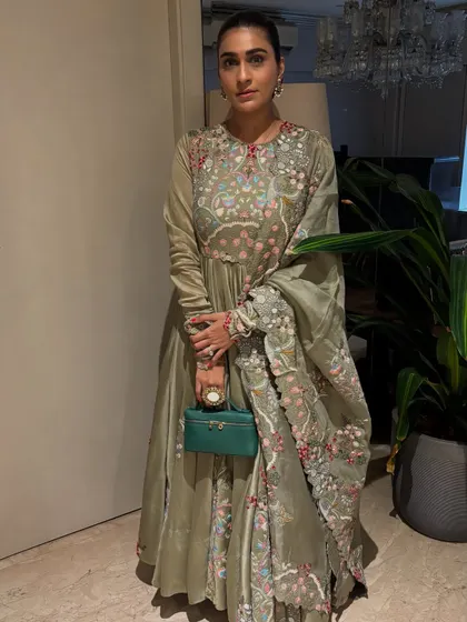 An elegant Anarkali in a muted green with delicate floral embroidery. This is a more traditional and graceful option for a festive event.