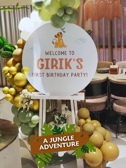 Welcome to Girik's first birthday party! This elegant jungle-themed welcome sign with a muted green and gold balloon garland greeted guests for a wild adventure.