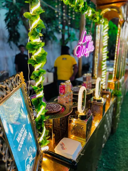 The full waffle counter, adorned with greenery and a fun neon sign.