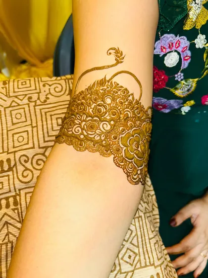 A close-up of the armband, showing the delicate floral and vine work that completes the full bridal look.