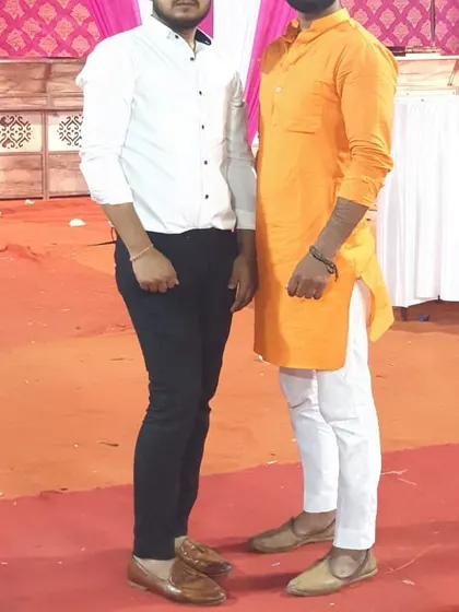 A client in a bright orange kurta paired with white pajamas. A simple, well-fitted kurta is a must-have for any man's wardrobe.