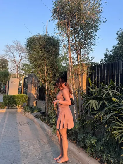 A side view of the pink mini dress, showing its backless design.